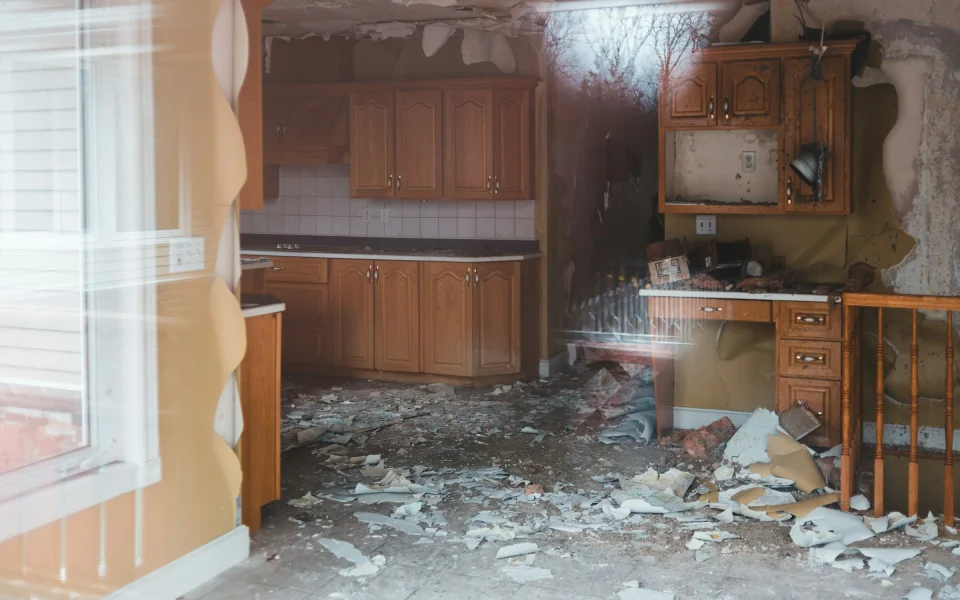 Water-damaged residential interior with debris